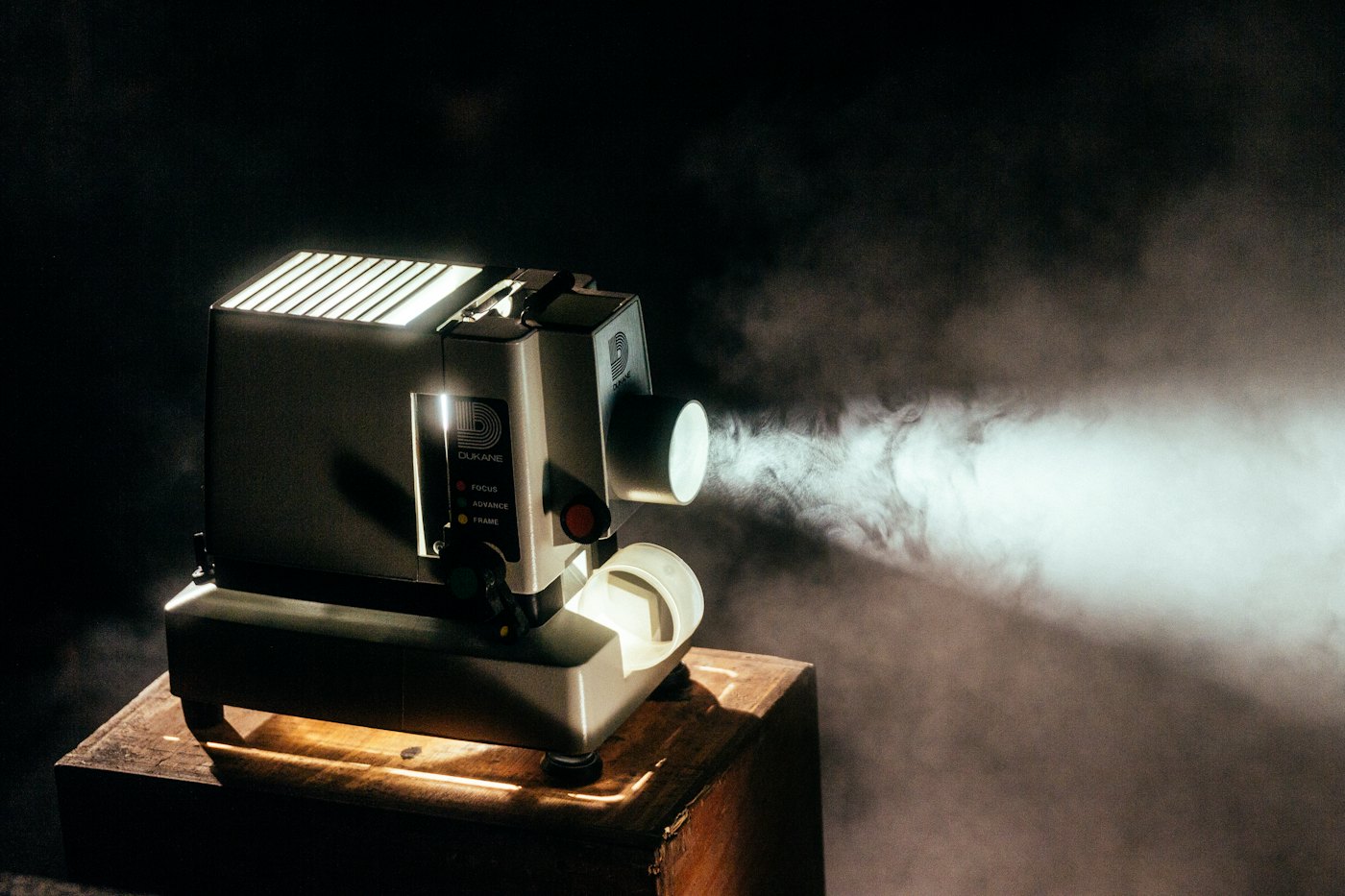 A film projector casting a beam of light through a dark room